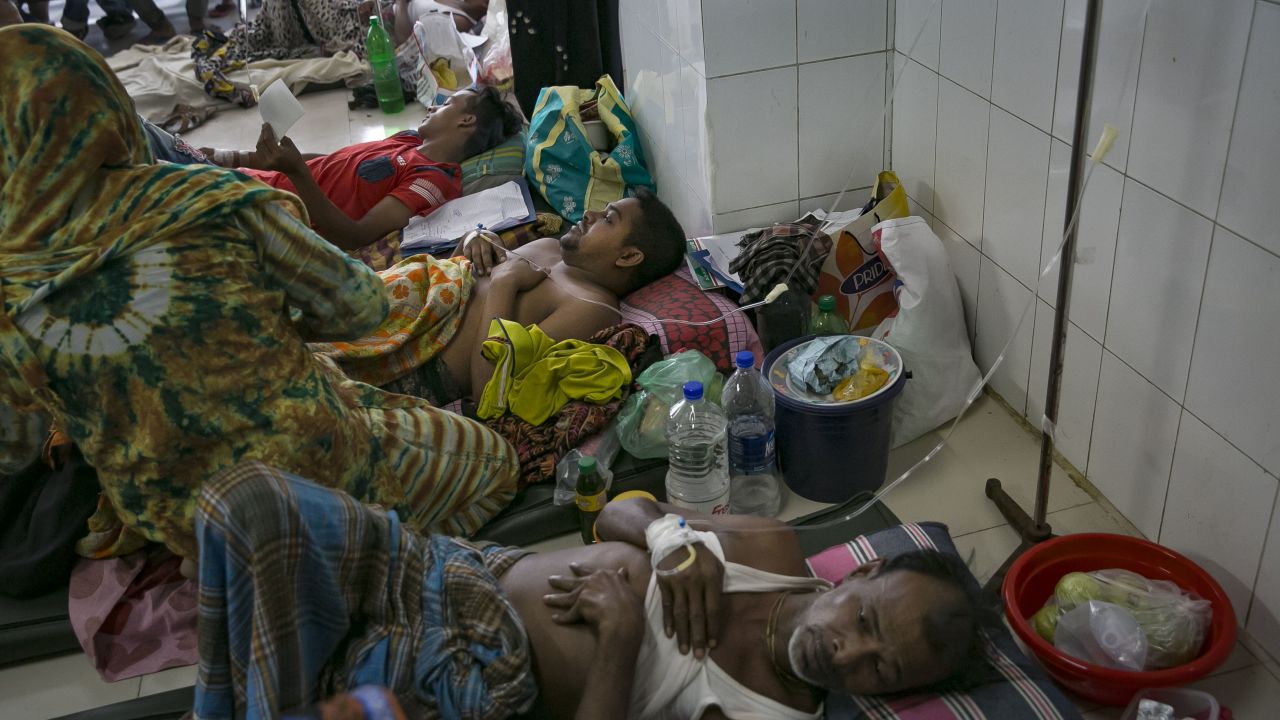 Bangladeshi patients suffering from dengue fever rest on the floor of a hospital ward in Dkaha.