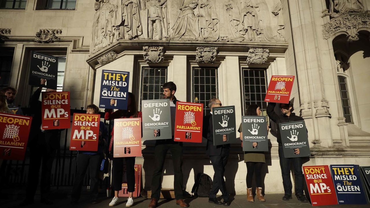 Protesters hold banners outside the Supreme Court in London, Tuesday Sept. 17, 2019. The Supreme Court is set to decide whether Prime Minister Boris Johnson broke the law when he suspended Parliament on Sept. 9, sending lawmakers home until Oct. 14 — just over two weeks before the U.K. is due to leave the European Union. (AP Photo/Matt Dunham)