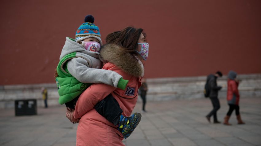 A woman and baby wearing face masks walk in the Forbidden City during heavy pollution in Beijing on February 28, 2013. Beijing residents were urged to stay indoors as pollution levels soared before a sandstorm brought further misery to China's capital. AFP PHOTO / Ed Jones        (Photo credit should read Ed Jones/AFP/Getty Images)