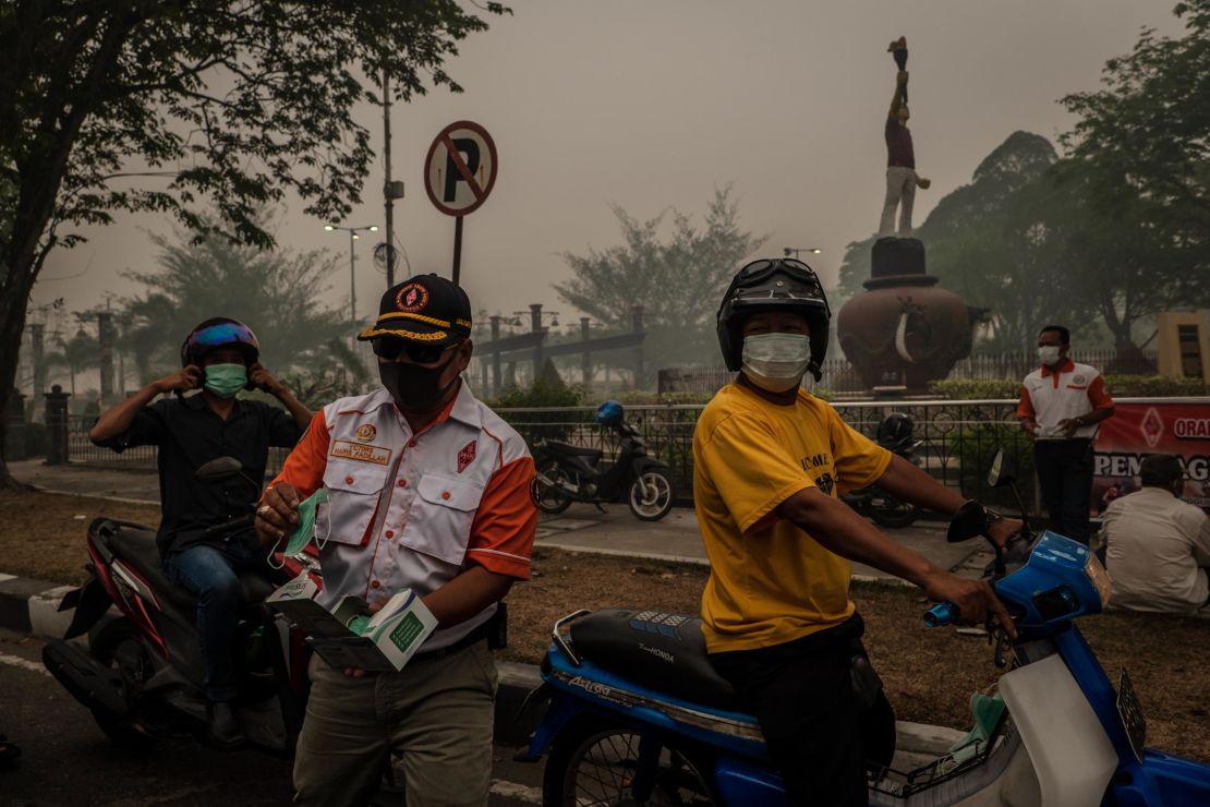 Motorcyclists wear protective masks in Palangkaraya city in Central Kalimantan.