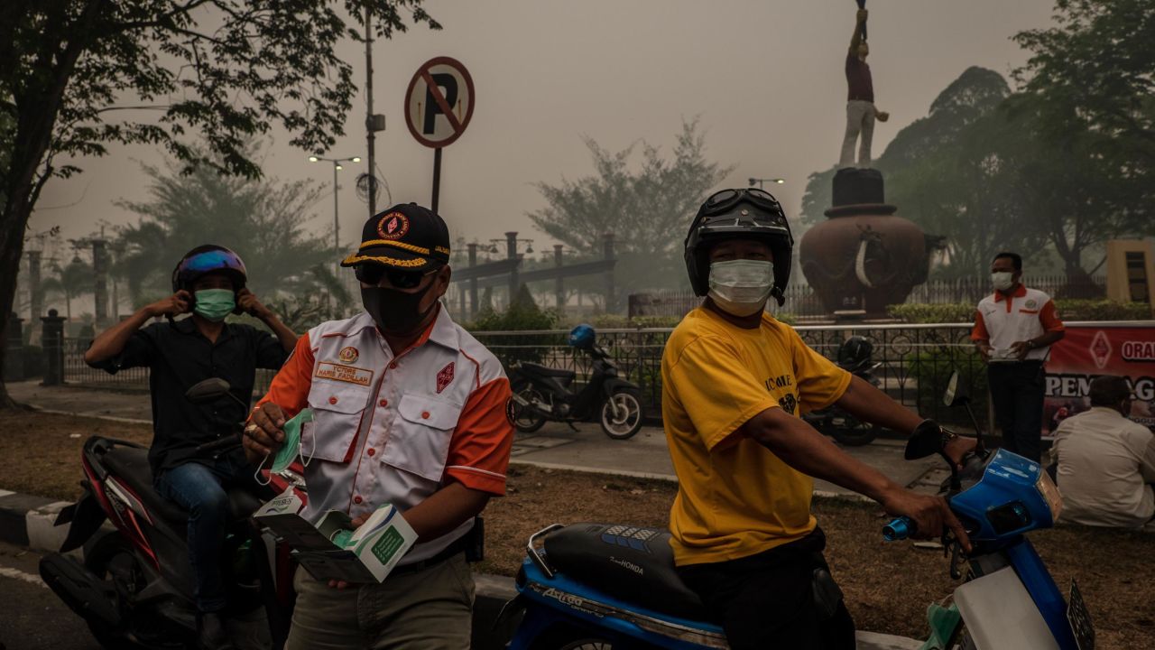 Motorcyclists wear protective masks in Palangkaraya city in Central Kalimantan.