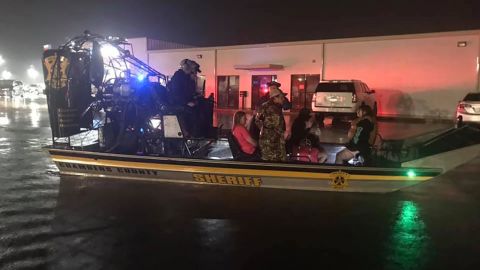 Chambers County rescuers use an airboat to ferry people to drier ground near Winnie on Thursday morning.