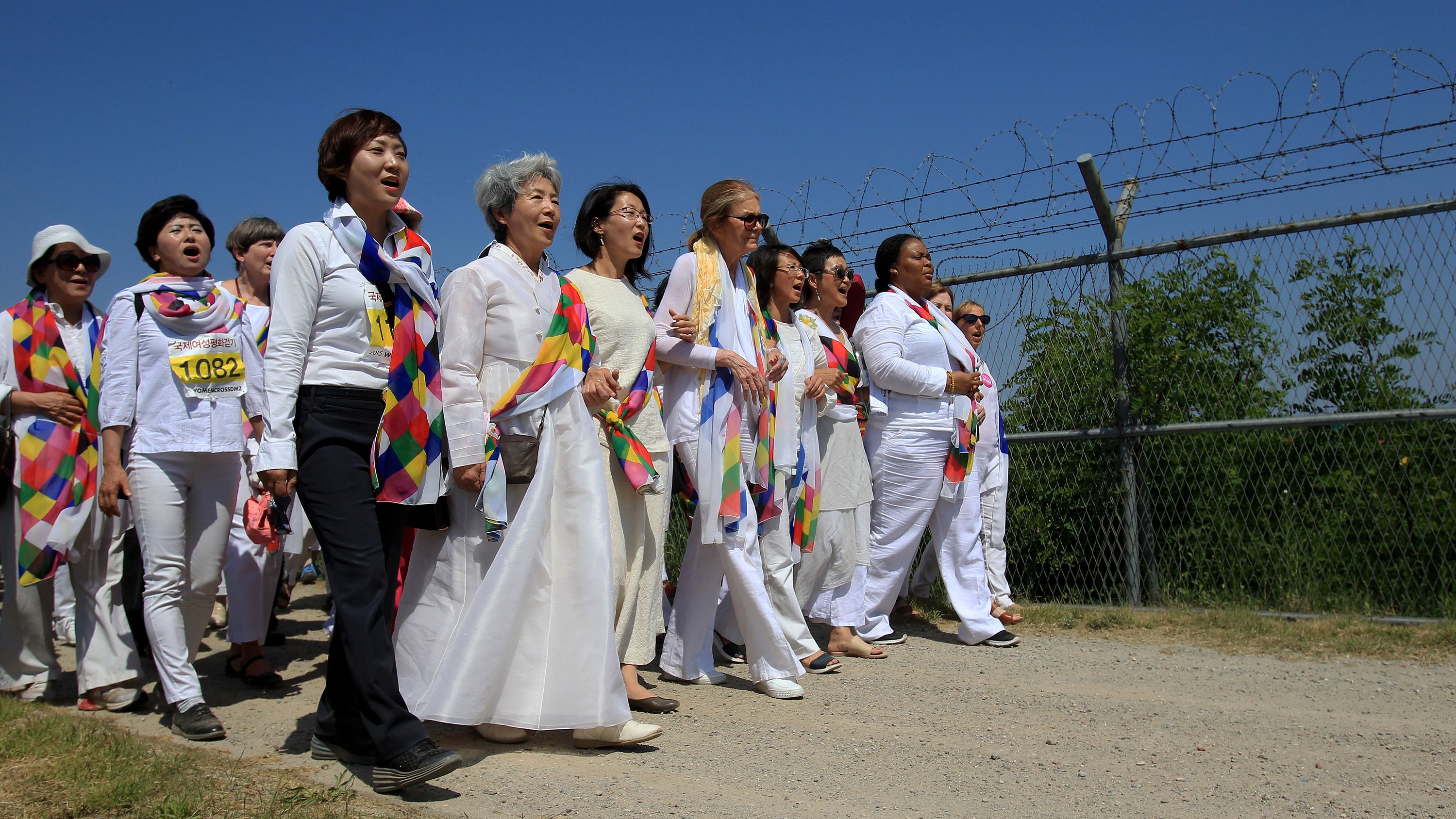 United States activist Gloria Steinem, center, marches with other activists to the Imjingak Pavilion along the military wire fences near the border village of Panmunjom on May 24, 2015 in Paju, South Korea.