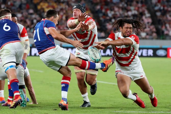 Japan's Shota Horie, right, and Pieter Labuschagne, center, block a kick by Russia's Dmitry Perov.