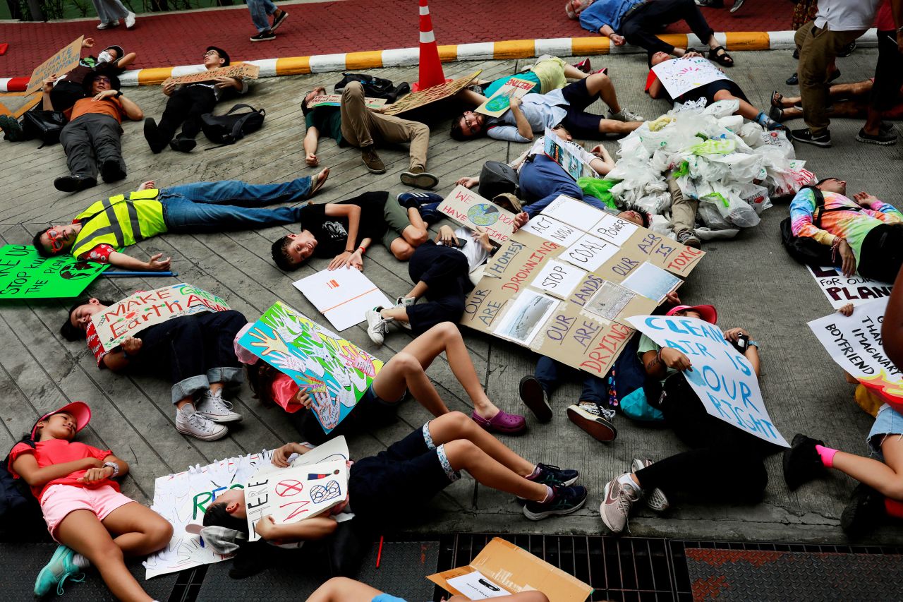 Protesters lie on the ground near the Ministry of Natural Resources and Environment in Bangkok.