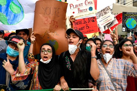People hold placards as they march in Lahore, Pakistan.