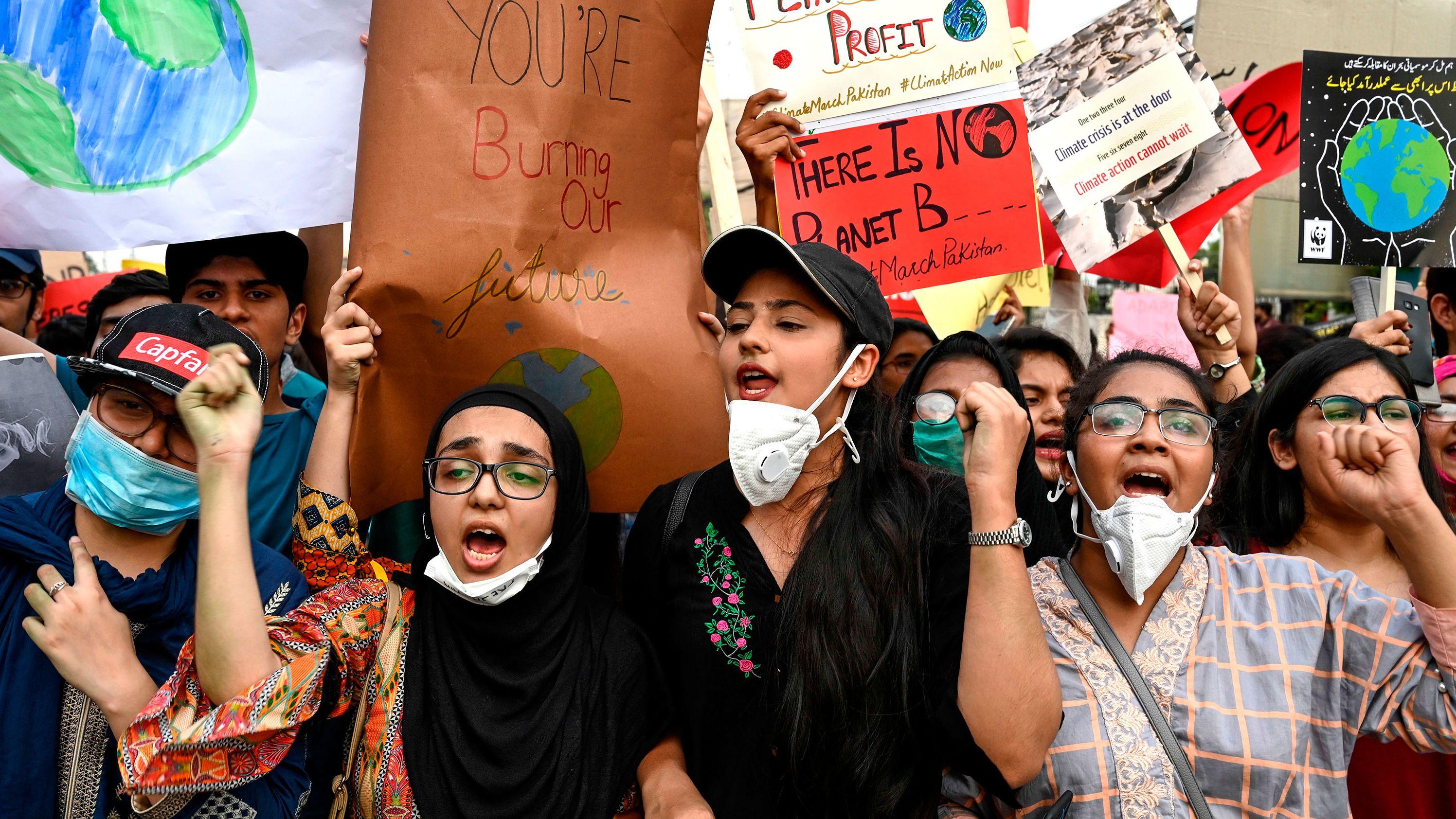 People hold placards as they march in Lahore, Pakistan.