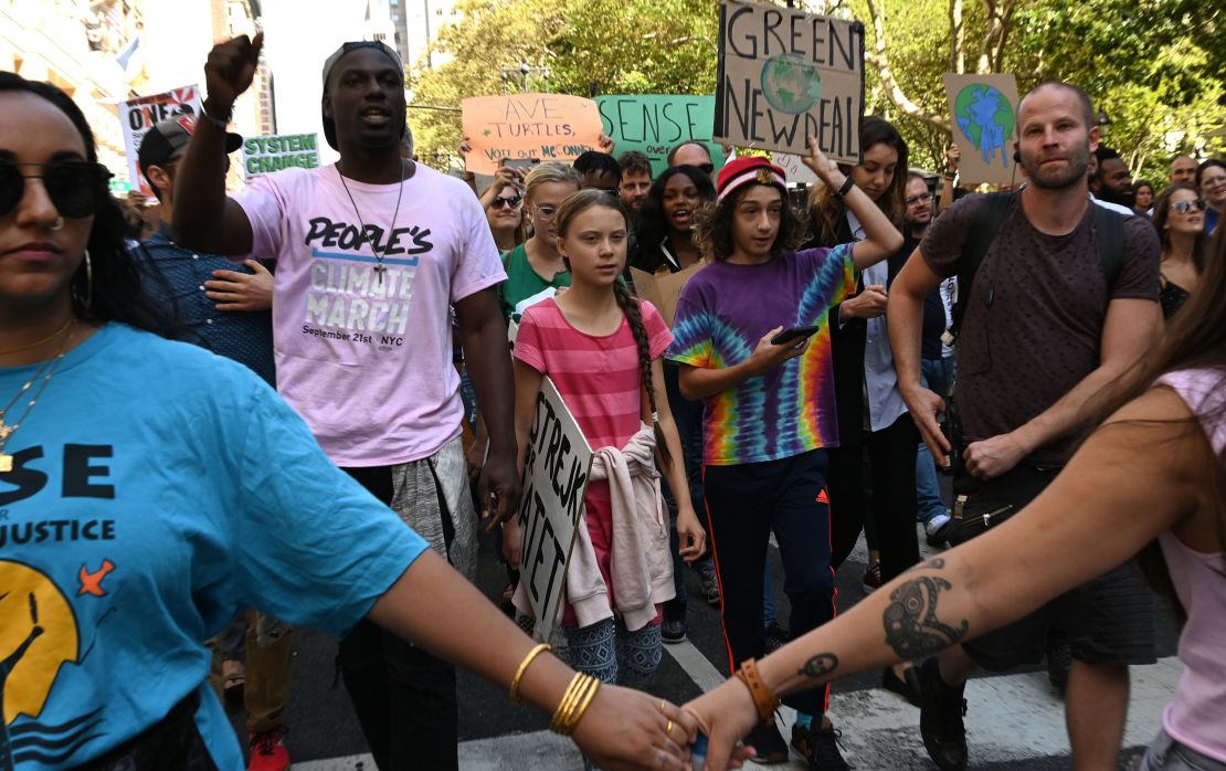 Teen climate activist Greta Thunberg walks with protesters during in New York  on Friday afternoon.