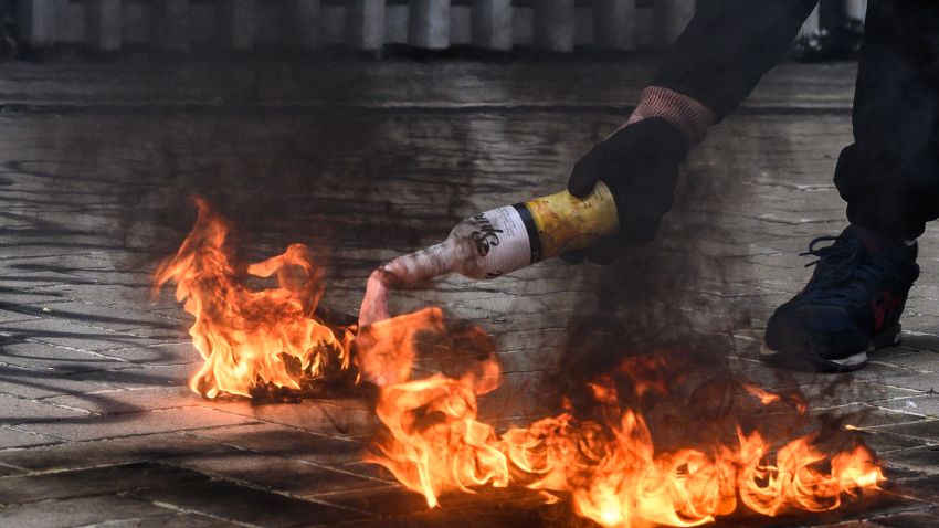 A protester uses a fire to light up a molotov cocktail before throwing it towards police stationed outside the government headquarters in Hong Kong on September 15, 2019. - Hong Kong riot police fired tear gas and water cannon at hardcore pro-democracy protesters hurling rocks and petrol bombs on September 15, tipping the violence-plagued city back into chaos after a brief lull in clashes. (Photo by ANTHONY WALLACE / AFP)        (Photo credit should read ANTHONY WALLACE/AFP/Getty Images)