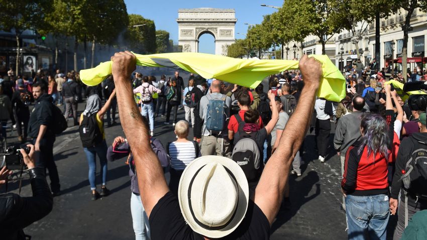 A man holds up a yellow vest in front of the Arc de Triomphe on the Champs Elysees avenue during an anti-government demonstration called by the "yellow vest" (gilets jaunes) movement, on September 21, 2019 in Paris. - The yellow vest (gilets jaunes) protests, which often descended into violent clashes with the police, erupted last November, with demonstrators accusing French President of being aloof and unaware of the needs of ordinary French people. (Photo by Lucas BARIOULET / AFP)        (Photo credit should read LUCAS BARIOULET/AFP/Getty Images)