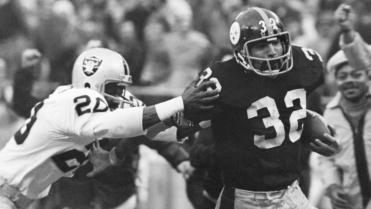 Franco Harris (32) eludes a tackle by Oakland Raiders' Jimmy Warren as he runs for a touchdown in an AFC Divisional game in January 1972.