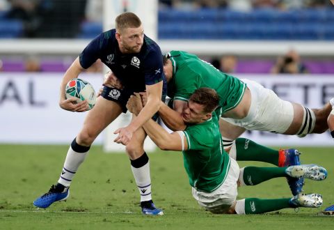 Scotland's Finn Russell looks to pass the ball as he is tackled by Irish players in Yokohama,