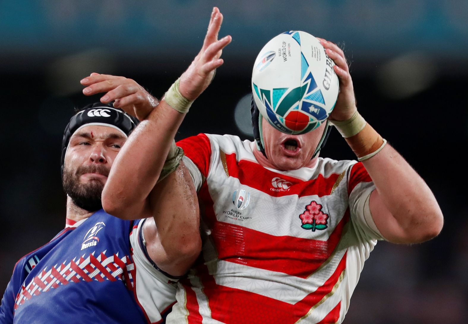 Russia's Andrei Ostrikov, left, competes for the ball with Japan's James Moore during their Rugby World Cup match in Tokyo, Japan, on Friday, September 20.