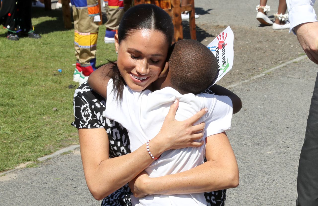 Meghan receives a hug from a young well-wisher in Cape Town on September 23.