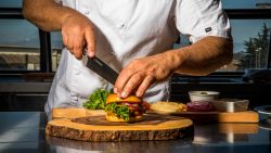 Moss Landing, CA - September 5, 2019: Chef Tucker Bunch prepares Sweet Earth's "Awesome Burger" in the test Kitchen at their Moss Landing headquarters.