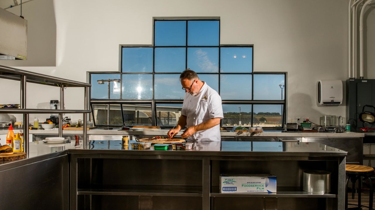 Tucker Bunch, culinary innovation and development chef at Sweet Earth, prepares food in the office's test kitchen. 