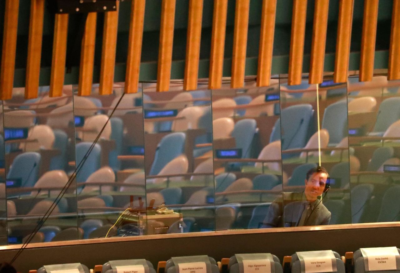 A language interpreter looks out from behind a glass wall inside the General Assembly Hall ahead of the Climate Summit.