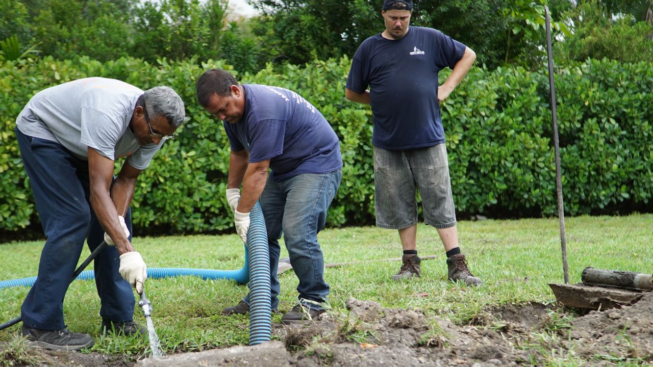 Septic tank repair workers flush out a septic system in Miami.