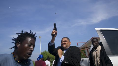Haitian Senator Ralph Fethiere fires a gun outside parliament in Port-au-Prince, Haiti on Sept. 23, 2019.