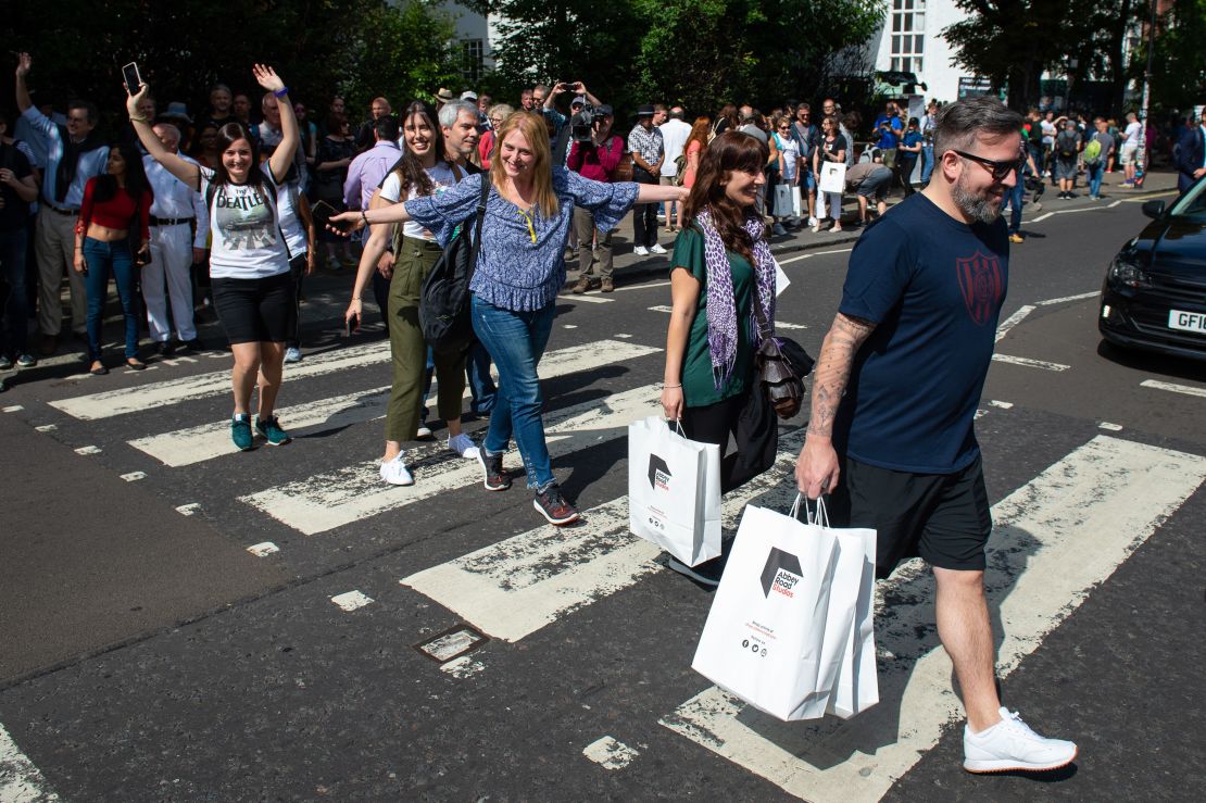 Beatles fans walk across the Abbey Road crossing in London on August 8, 2019, to mark the 50th anniversary of the eponymous album's release. 