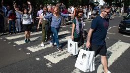 Beatles fans walk across the Abbey Road crossing in London on August 8 2019 to mark the 50th anniversary of the iconic cover album. 