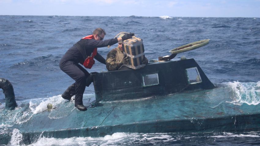 U.S. Coast Guard boarding team members climb aboard a suspected smuggling vessel in September. Crews intercepted a drug-laden, 40-foot self-propelled semi-submersible (SPSS) in the Eastern Pacific carrying approximately 12,000 pounds of cocaine, worth over $165 million and apprehended four suspected drug smugglers. (U.S. Coast Guard Photo)