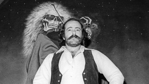 Robert Hunter poses in front of a Blues For Allah backdrop at the Grateful Dead's rehearsal studio, Club Front, in November 1977 in California.