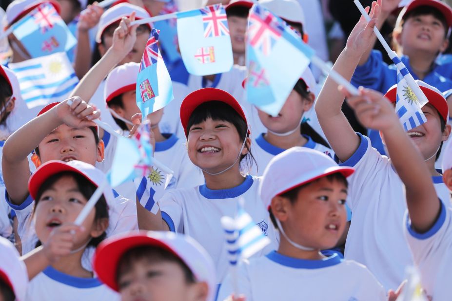 Local children cheer with both Fiji and Uruguay flags at the Kamaishi Recovery Memorial Stadium, a venue built in memory of those lost in the 2011 tsunami. 