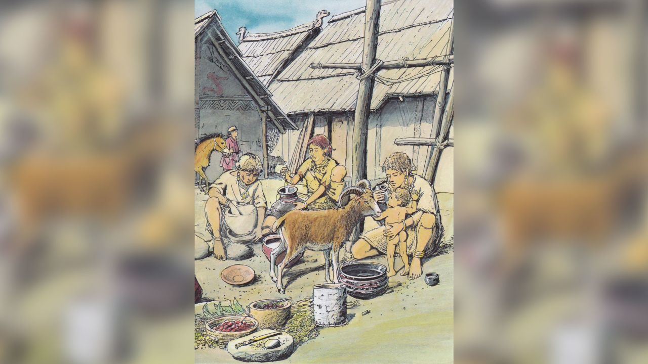 This is a prehistoric family scene showing an infant being fed with baby bottle.