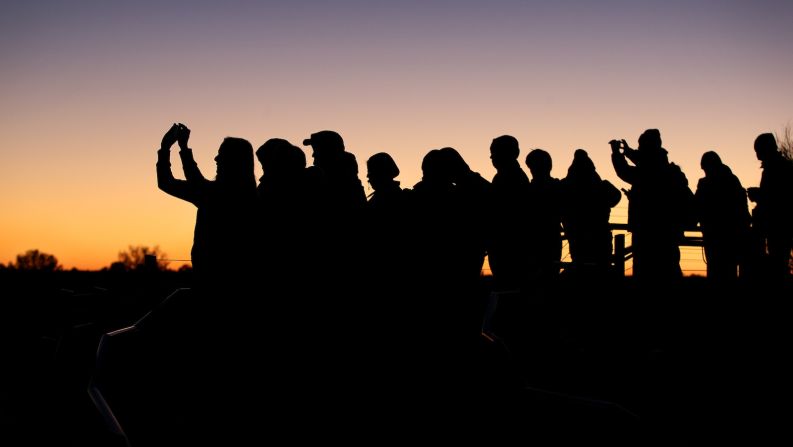 <strong>Visitor influx: </strong>Park visitors take photos during sunrise from a viewing area at Uluru in August. Local operators say the next few weeks will be hectic as visitors rush to climb the rock, mostly Australian families, retirees and Japanese tourists (who have long been avid climbers of Uluru).