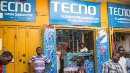 Branding for Tecno Mobile sits above vendor kiosks at Jagwal Electronics Market in Maiduguri, Nigeria, on Wednesday, May 1, 2019. Nigeria will propose a supplementary budget later this year to boost capital spending and fund a 67 percent increase in the minimum wage as government revenues improve, Budget Minister Udo Udoma said. Photographer: Jean Chung/Bloomberg via Getty Images