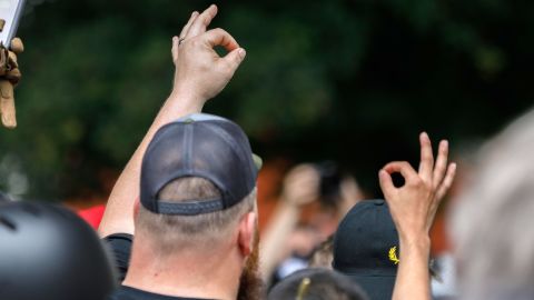 Members of the far-right group "Proud Boys" make the OK hand gesture at a rally in Portland, Oregon.