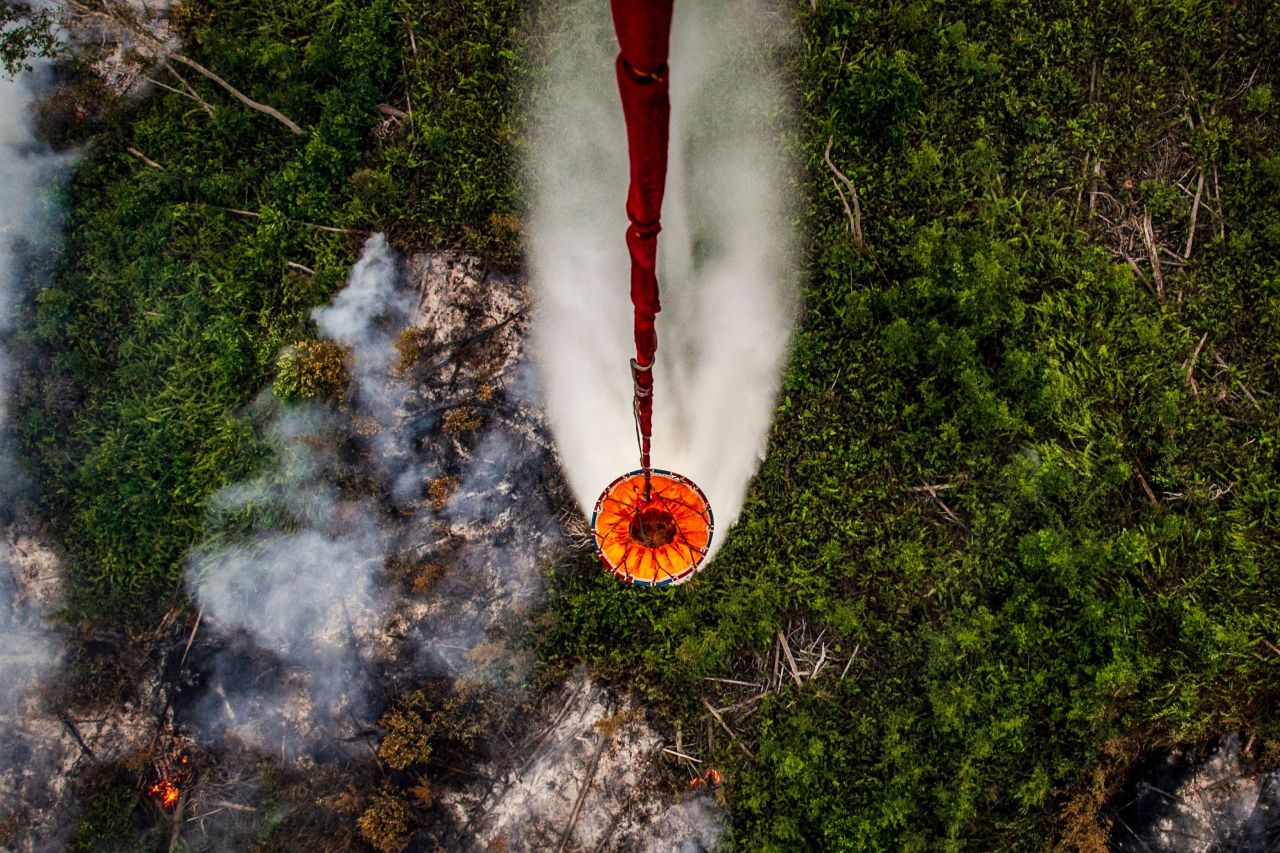 A helicopter drops water on forest fires in Kapuas Hilir, Indonesia, on Saturday, September 21. <a href="https://www.cnn.com/2019/09/24/asia/indonesia-red-planet-haze-intl-hnk/index.html" target="_blank">Toxic haze from the fires</a> continues to affect residents across the country.