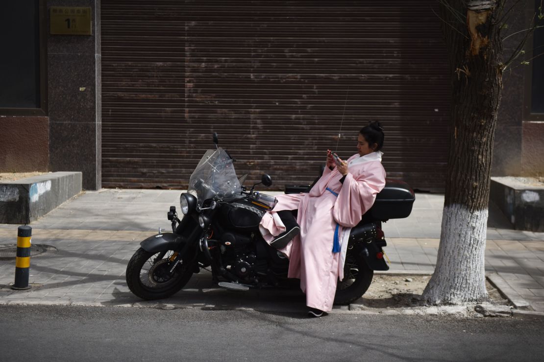 A fan takes a break outside a gathering of Hanfu devotees at a park in Beijing. 