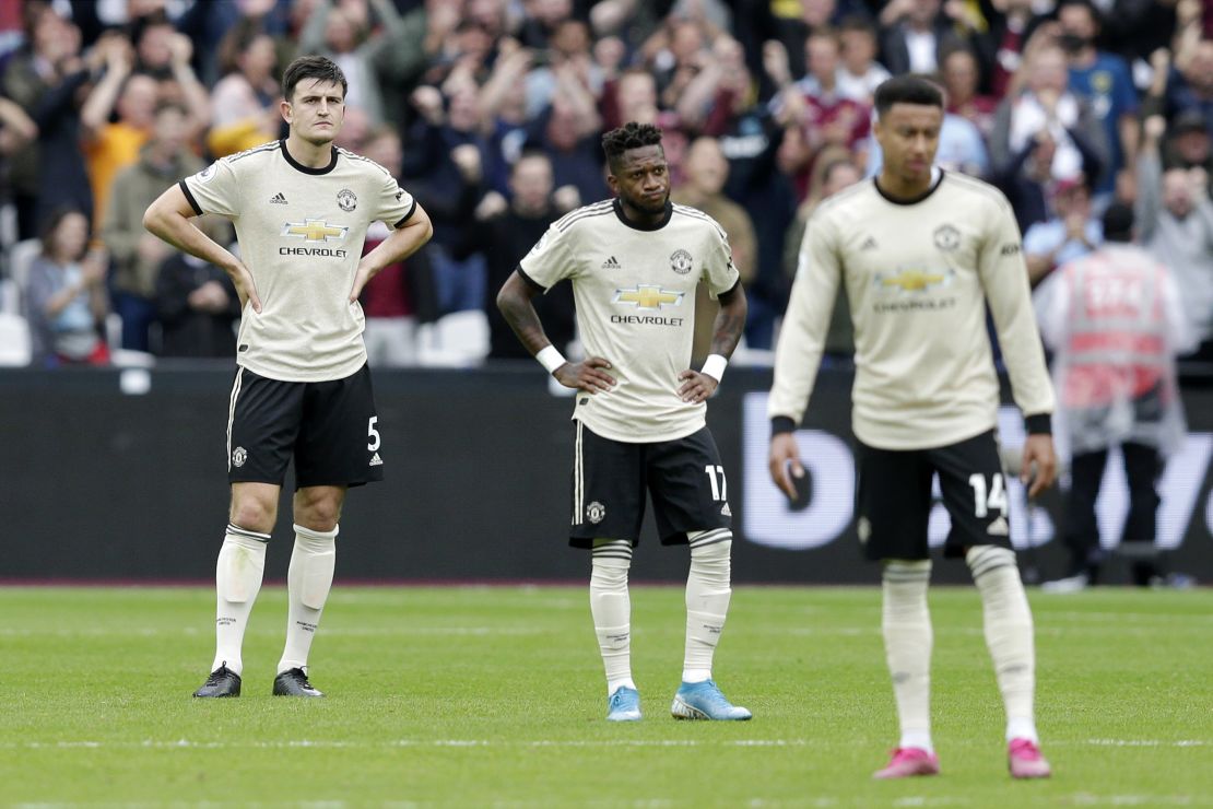 Fred (C) of Manchester United looks dejected with Harry Maguire (L) after West Ham's second goal.
