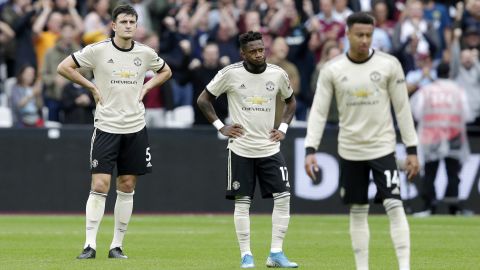 Fred (C) of Manchester United looks dejected with Harry Maguire (L) after West Ham's second goal.

