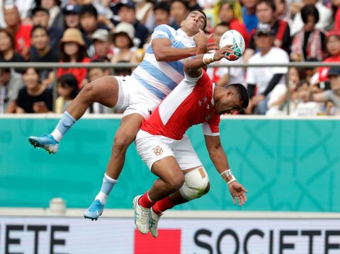 Argentina's Santiago Carreras and Tonga's Viliami Lolohea compete for the ball during the Rugby World Cup Pool C game.