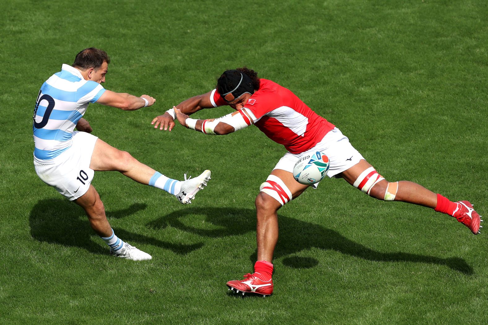 Benjamin Urdapilleta of Argentina kicks the ball under pressure of Zane Kapeli of Tonga his side's bonus-point victory. 