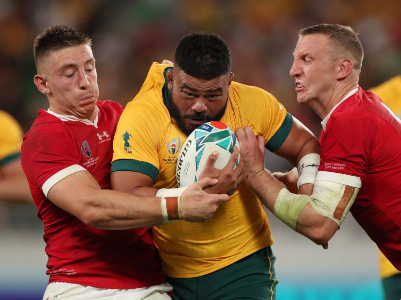 Tolu Latu of Australia is tackled by Josh Adams and Hadleigh Parkes of Wales.