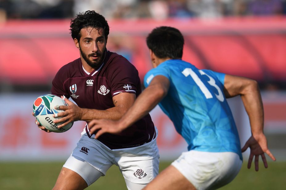 Georgia's centre Giorgi Kveseladze (left) runs with the ball in his side's 33-7 win over Uruguay.