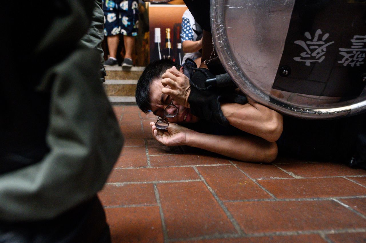 A man is detained by Hong Kong police during a protest in the Cau