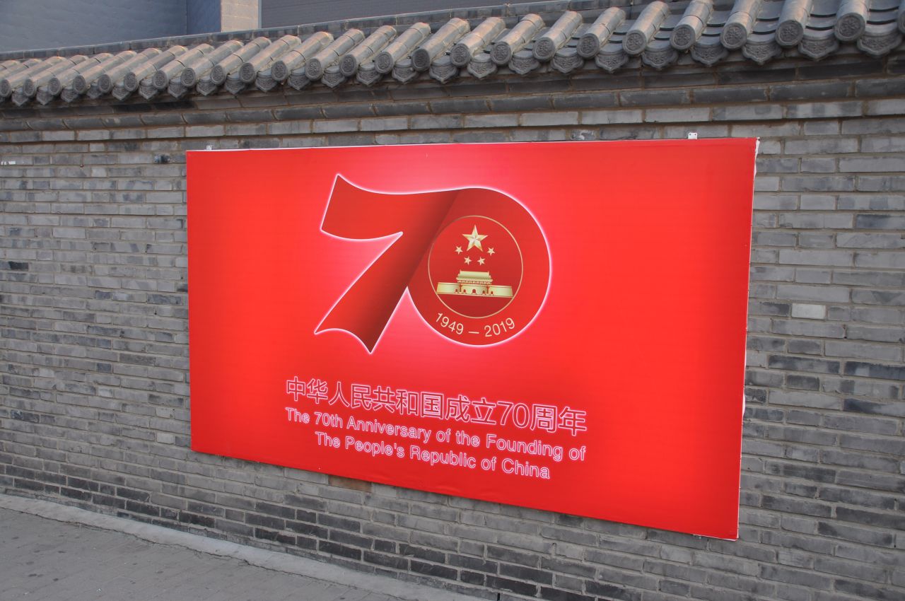 A sign celebrating the 70th anniversary of the People's Republic of China on a wall next to Tiananmen Square.