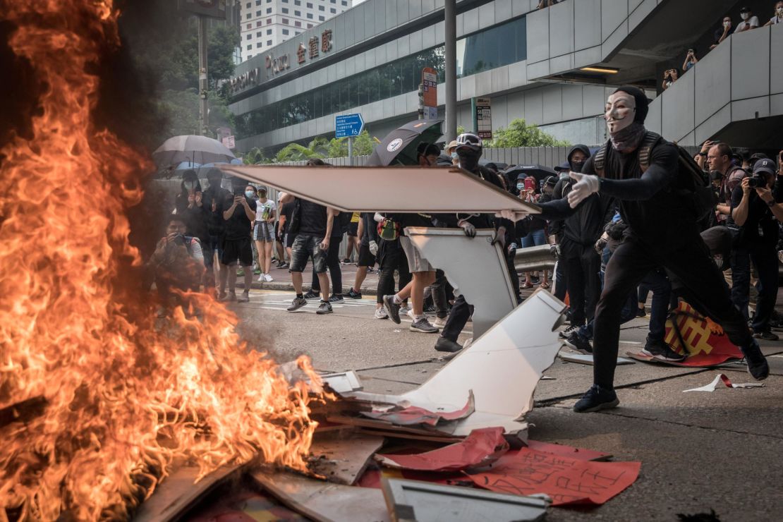 A pro-democracy protester burns a banner during a march in Hong Kong. 