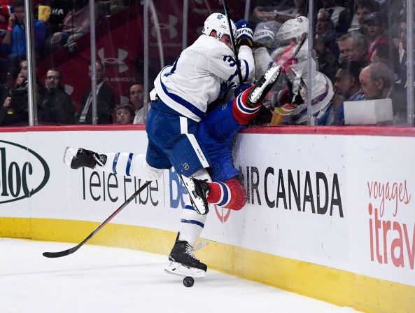 Toronto Maple Leafs defenseman Justin Holl checks Montreal Canadiens forward Jesperi Kotkaniemi into the boards during the first period of their NHL hockey game Montreal, Canada, on September 23.