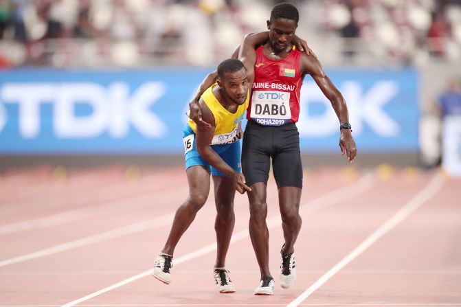 Braima Suncar Dabo of Guinea-Bissau, right, helps Jonathan Busby of Aruba across the finish line in the men's 5000 meters heat during day one of the IAAF World Athletics Championships Doha 2019 at Khalifa International Stadium, in Doha, Qatar, on September 27.