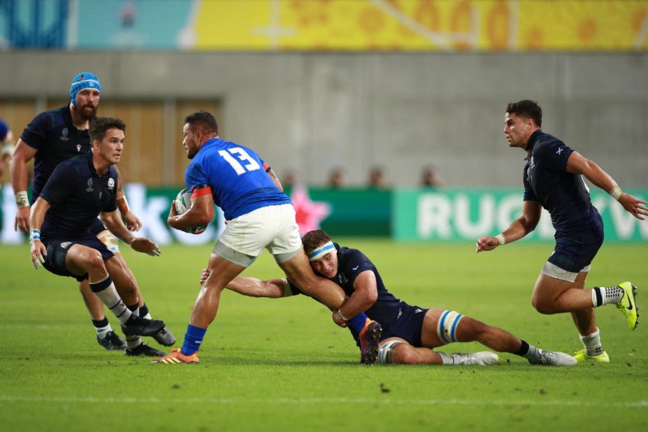 Alapati Leiua of Samoa is tackled by Jamie Ritchie of Scotland in a bruising match in Kobe. 