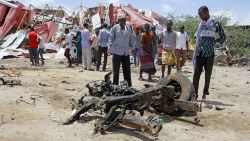 Somalis watch the wreckage of the car bomb after an attack on a European Union military convoy in the capital Mogadishu, Somalia Monday, Sept. 30, 2019. A Somali police officer says a suicide car bomber has targeted a European Union military convoy carrying Italian military trainers in the Somali capital Monday. (AP Photo/Farah Abdi Warsameh)