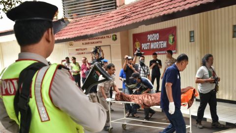 Indonesian police and forensic officials shift the body of a Canadian citizen who was killed during the January 14, 2016 terrorist attacks in Jakarta. The weapons used during the attack were funded by Adi Jihadi, who had taken a radicalized domestic worker from Hong Kong as his second wife.