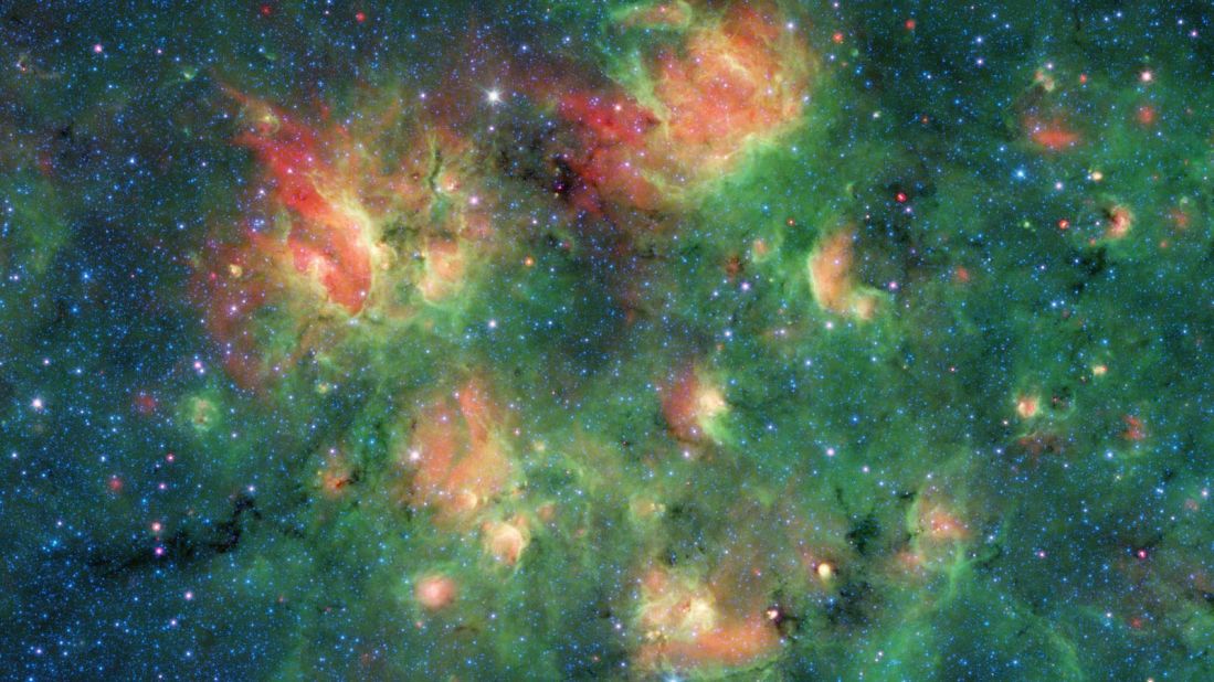 This infrared image from Spitzer shows a cloud of gas and dust full of bubbles, which are inflated by wind and radiation from massive young stars. Each bubble is filled with hundreds to thousands of stars, which form from dense clouds of gas and dust.