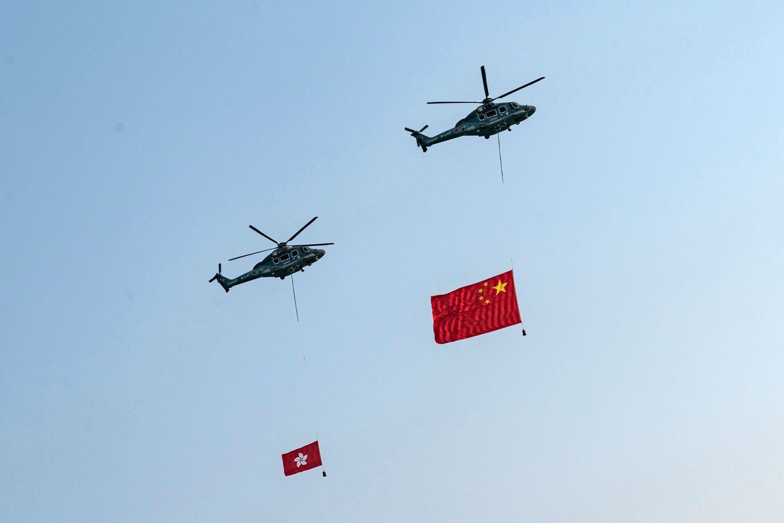 Helicopters fly the flags of China and Hong Kong over Victoria Harbour during a flag-raising ceremony at Golden Bauhinia Square in Hong Kong.
